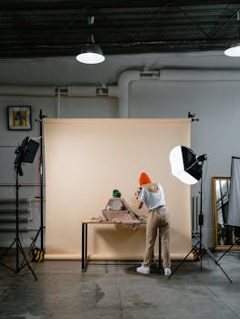 Photographer capturing a still life in a well-equipped studio with soft lighting.