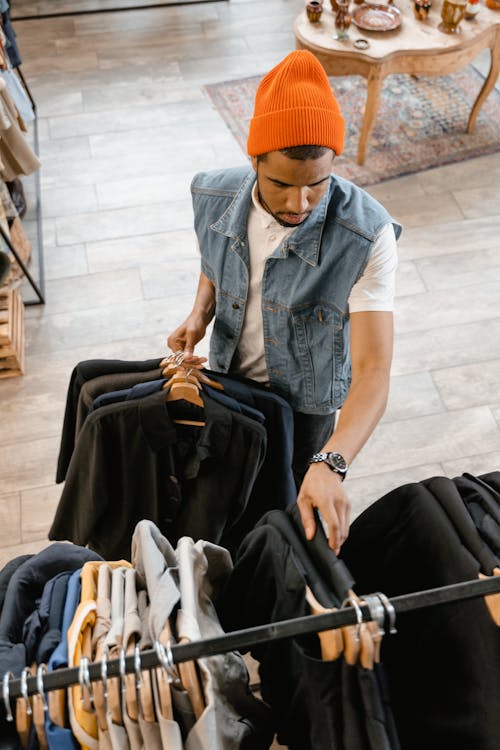 A Man Putting Clothes on Display