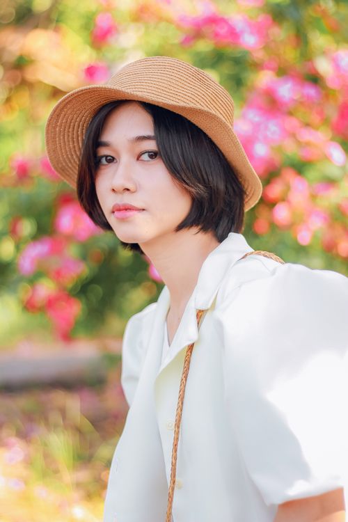 Free Young ethnic female in elegant white wear and hat looking at camera on sunny day Stock Photo