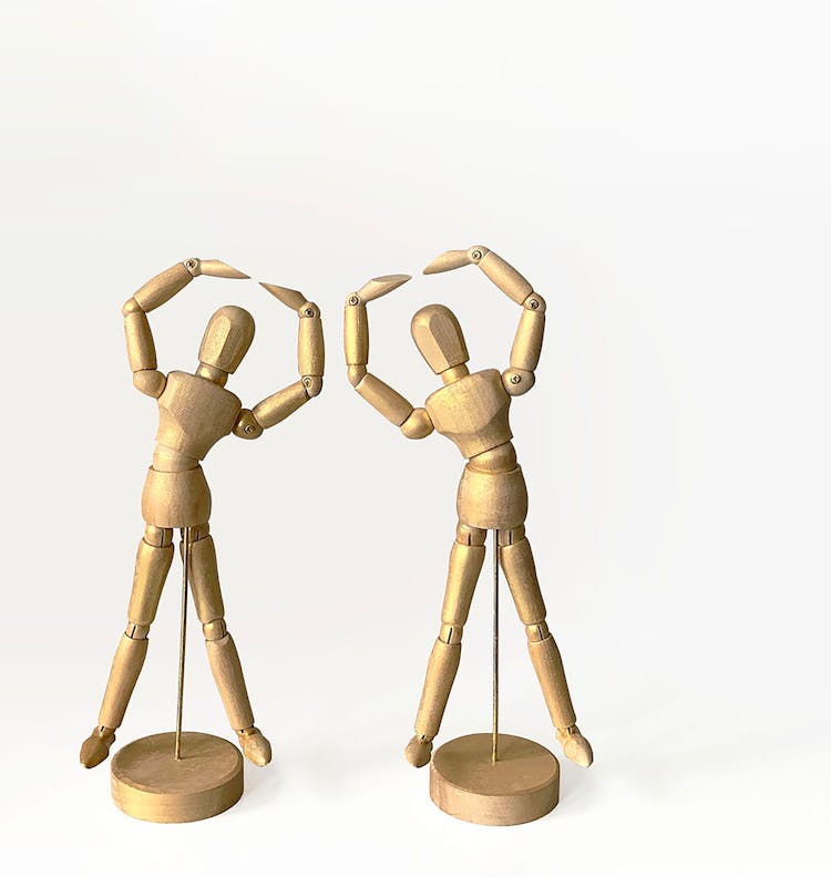 Brown Wooden Human Figures On A White Background