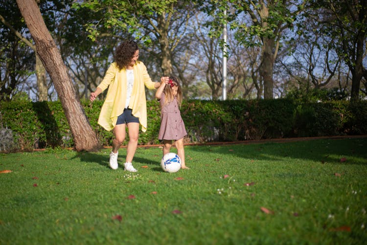 A Mother And Her Daughter Playing Outside