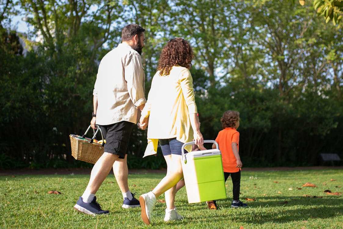 Man and Woman Walking at the Park with Child