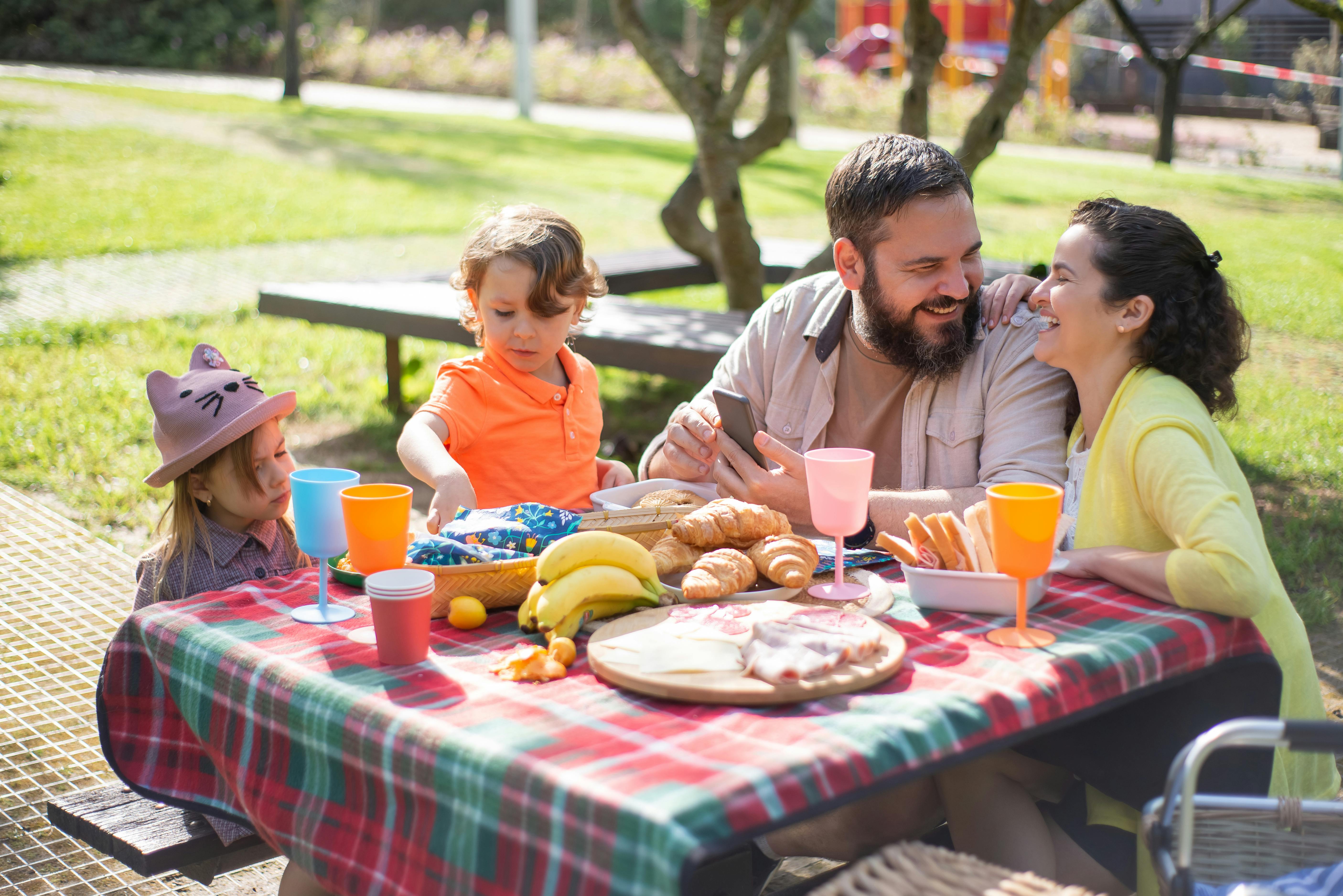 man and woman having picnic with the children