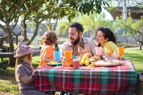 Free Family of four enjoying an outdoor picnic on a sunny day in a park in Portugal. Stock Photo