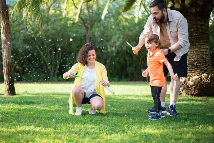 A Happy Family Playing On The Grassy Field