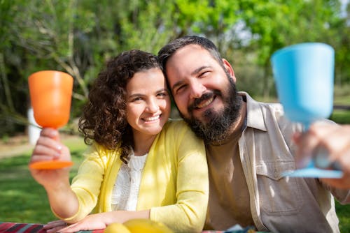 Man and Woman Holding Cups