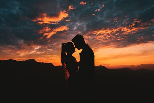 Free Silhouette of a Couple Facing Each Other Stock Photo