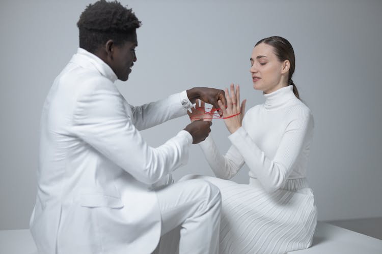 A Man And Woman Playing Red Thread Together