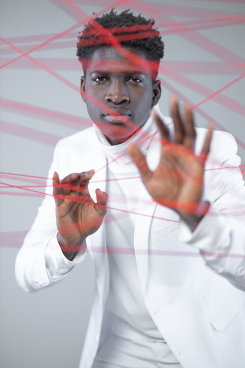 Man in White Clothes Holding on a Red String 