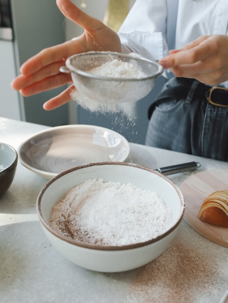 A Baker Sifting Flour