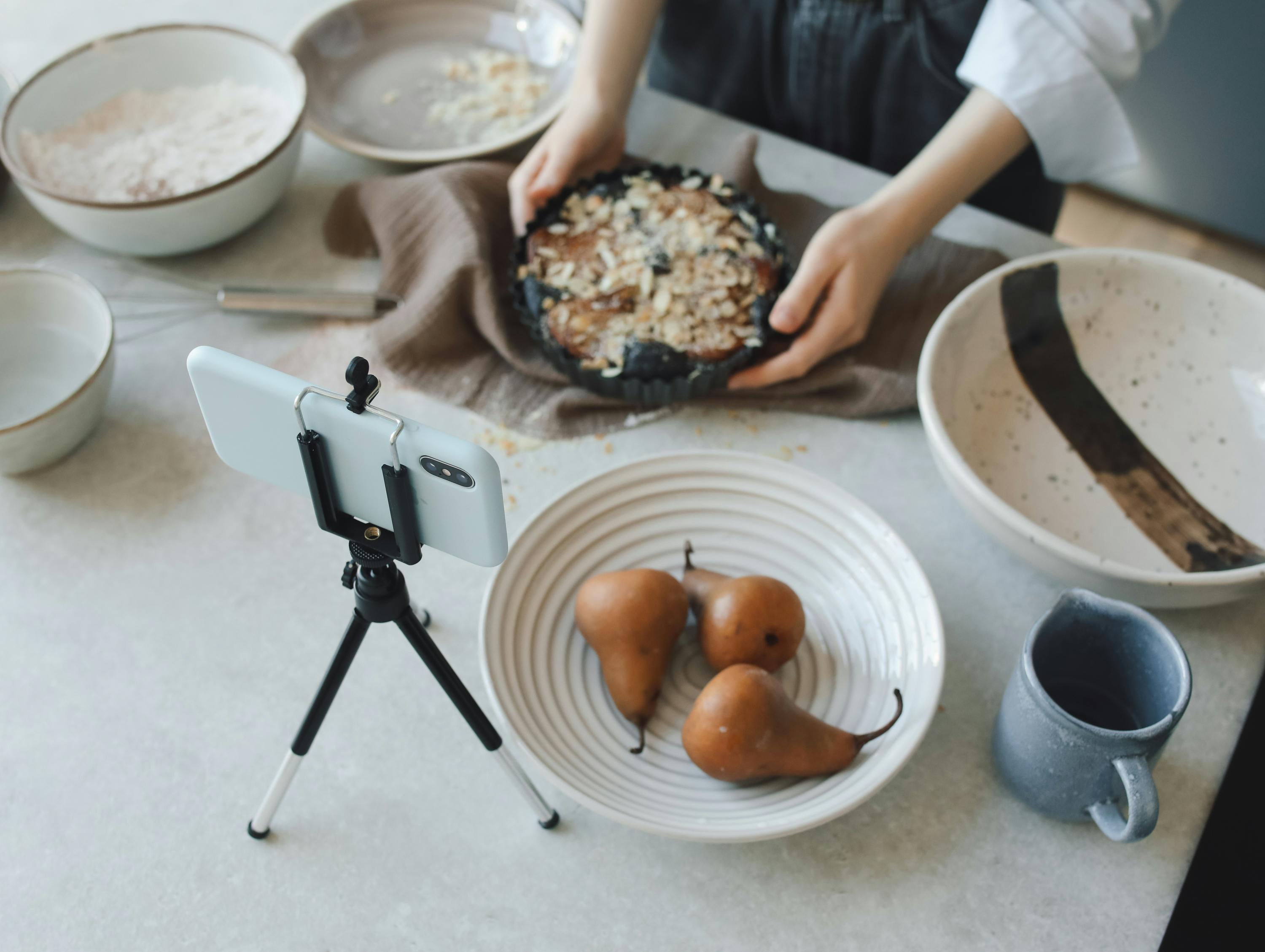 woman in white blazer cooking while vlogging