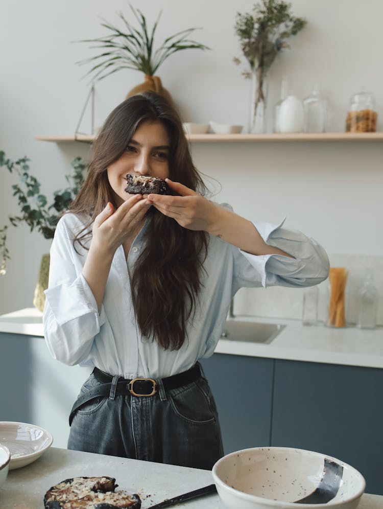 
Woman Smelling Sliced Chocolate Cake