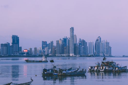 Stunning view of Panama City skyline with boats on the water at dusk.