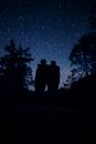 Silhouette of Man and Woman Standing on Road during Night Time