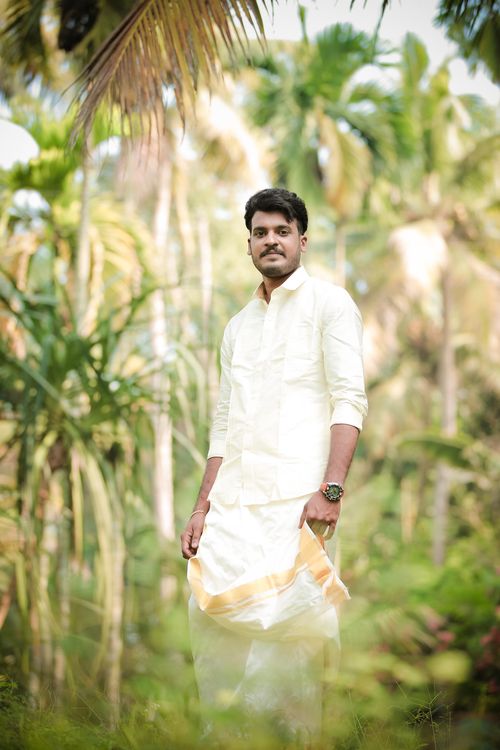Free Indian groom in traditional attire posing amidst lush tropical vegetation, perfect for wedding themes. Stock Photo