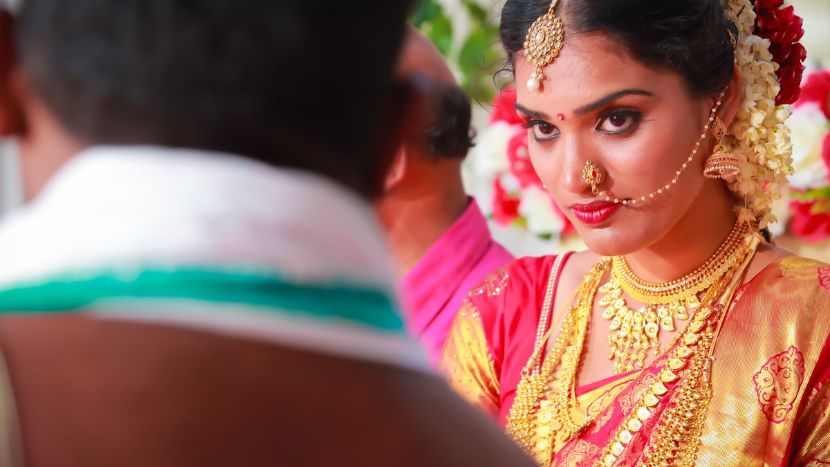 Bride in a red and gold silk sari with traditional jewellery (Post-Wedding Catering in Vellore)