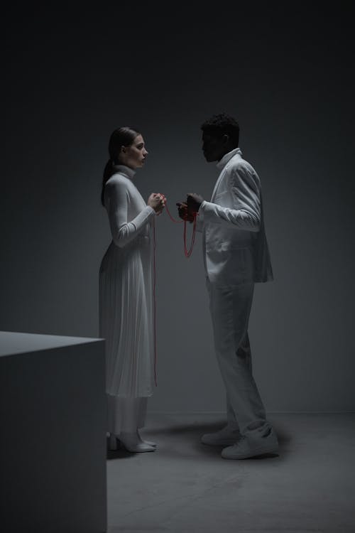 Free Man and Woman in White Clothes Holding a String Stock Photo