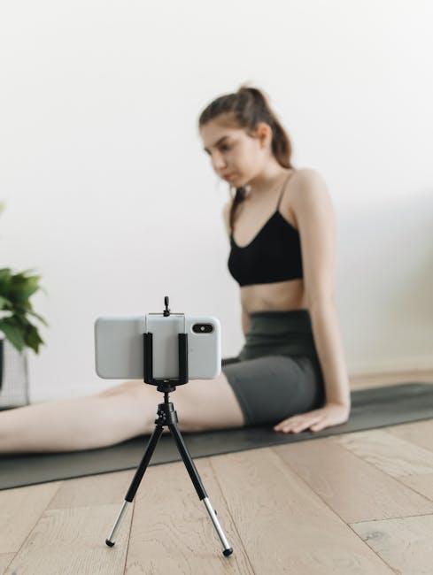 Fitness Influencers Monetization Report 2025: Why Old Digital Products Are Failing 4 A woman practicing yoga indoors while recording her session on a smartphone.