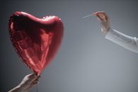Person Holding Red Heart Balloon
