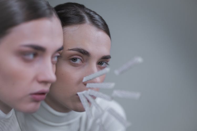 A Woman's Face Reflection Over A Mirror