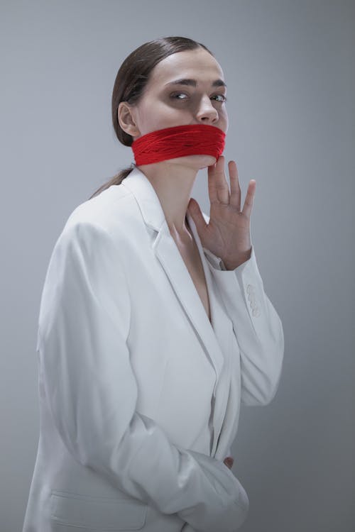 Free Woman in White Button Up Long Sleeve Shirt With Red Plastic Cover on Face Stock Photo
