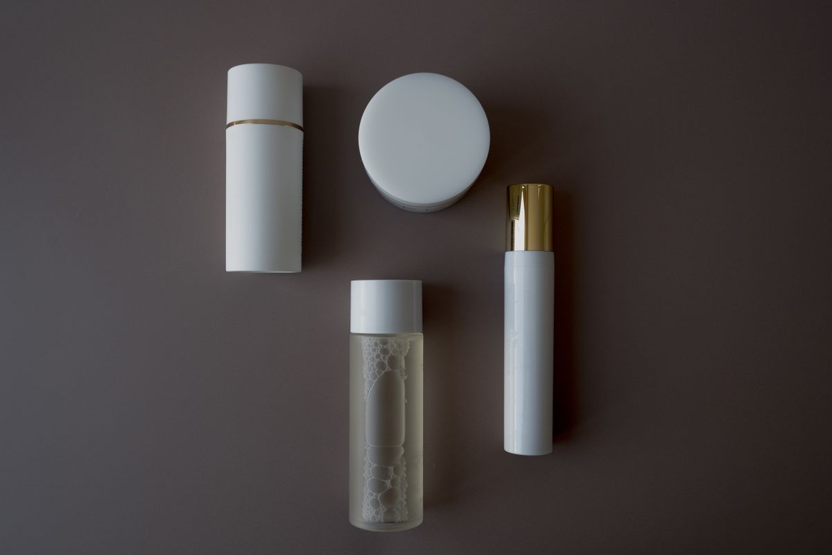 Top view of skincare bottles and flasks on a sleek surface — packaging and product design
