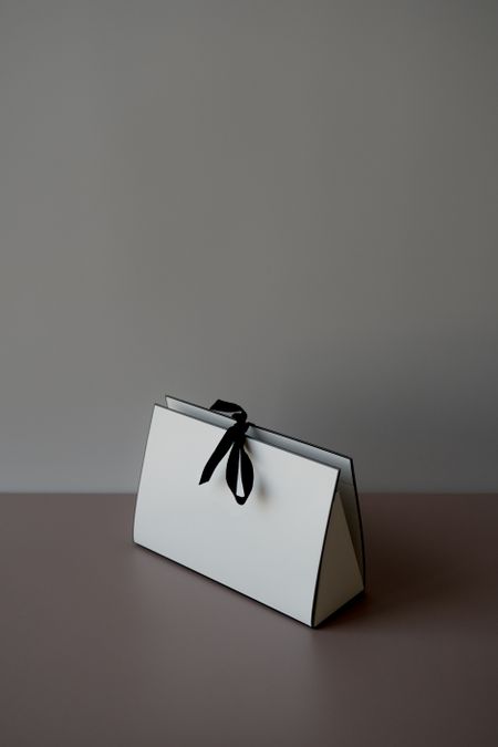 Plain white carton package tied with a dark ribbon — photo by alleksana on Pexels