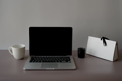 Free Laptop Beside a Cup on a Desk Stock Photo