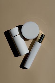 Minimalist flat lay of skincare products on beige background with shadows.