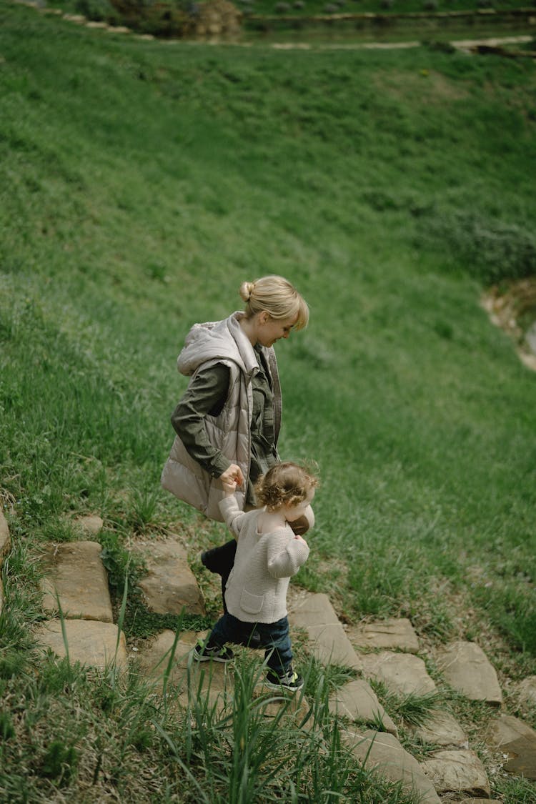 A Mother Walking Down The Stairs With Her Child