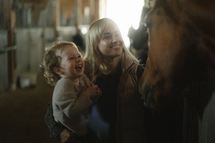 Woman And Child Looking At A Brown Horse