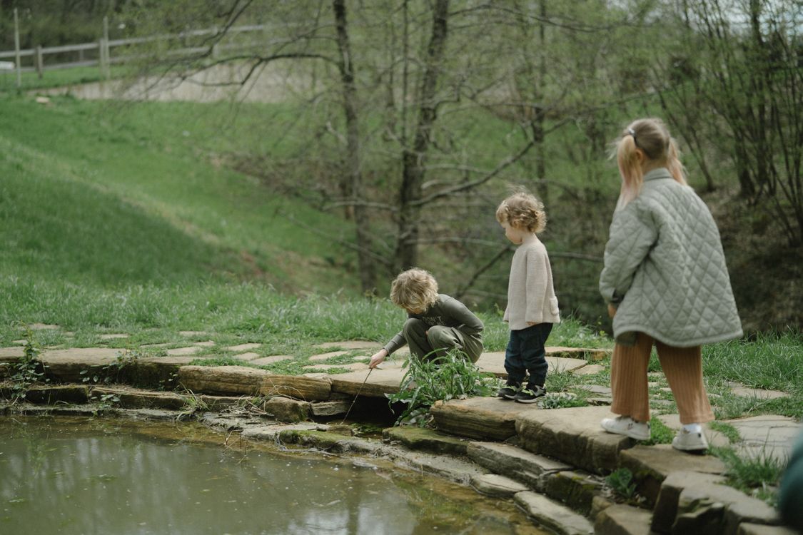 Kids Walking on Concrete Floor near Body of Water · Free Stock Photo