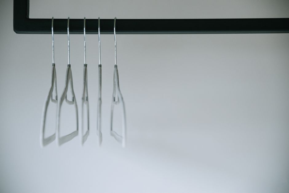 A Foldable Clothes Rack for the Modern Bachelor Pad: 5 Essential Considerations Young adult male standing in modern urban living space with foldable clothes rack for compact storage