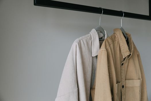 Close-up of beige shirts on hangers, showcasing minimalist style.