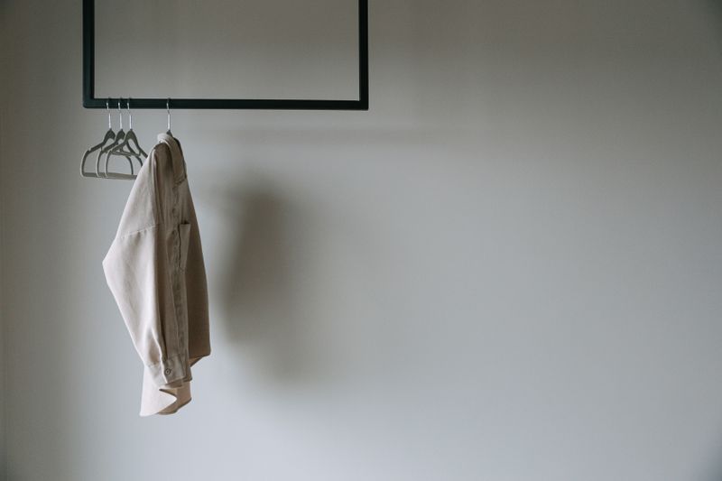 navy blazer hanging on a wooden hanger
