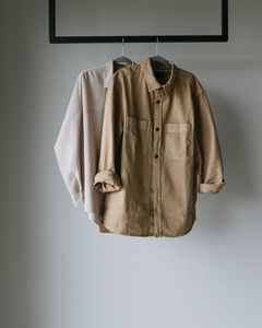 Two neutral shirts hanging on a rack, perfect for minimalist fashion concepts.
