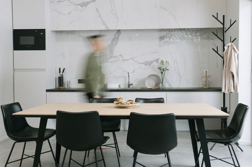 Free Sleek and modern kitchen dining area with a marble backsplash, minimalist design, and stylish furniture. Stock Photo