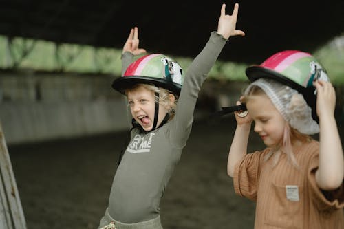 Two Kids Wearing Helmets and Feeling Happy