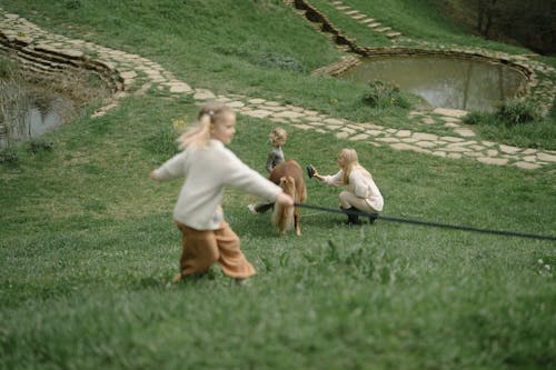 Kids Playing on Grass with Their Mother