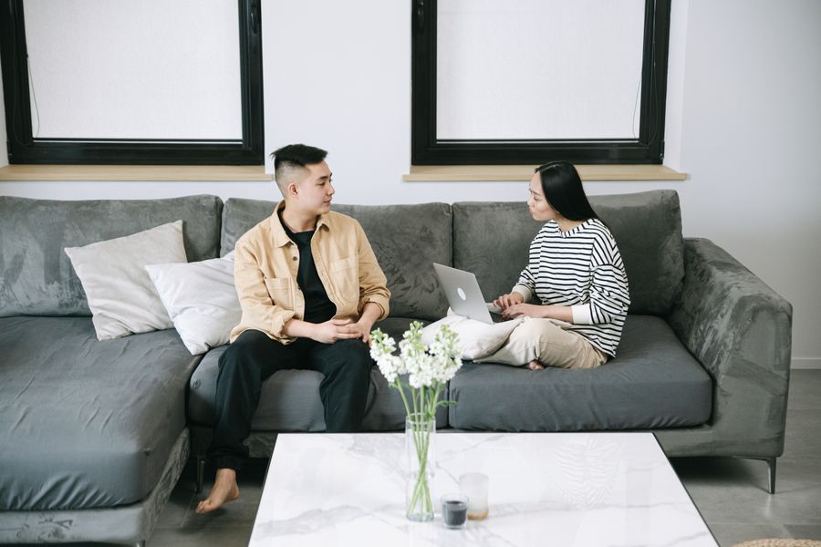 Cặp đôi ngồi trên sofa cùng xem một kế hoạch trên laptop