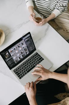 Aerial shot of a person working on a laptop with coffee, ideal for remote work and productivity themes.