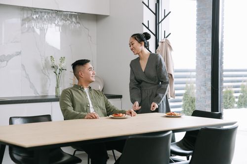 Free A couple enjoying a meal in a modern dining room filled with natural light. Stock Photo