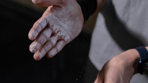 Close-up image of hands with gym chalk, emphasizing preparation for a workout session.