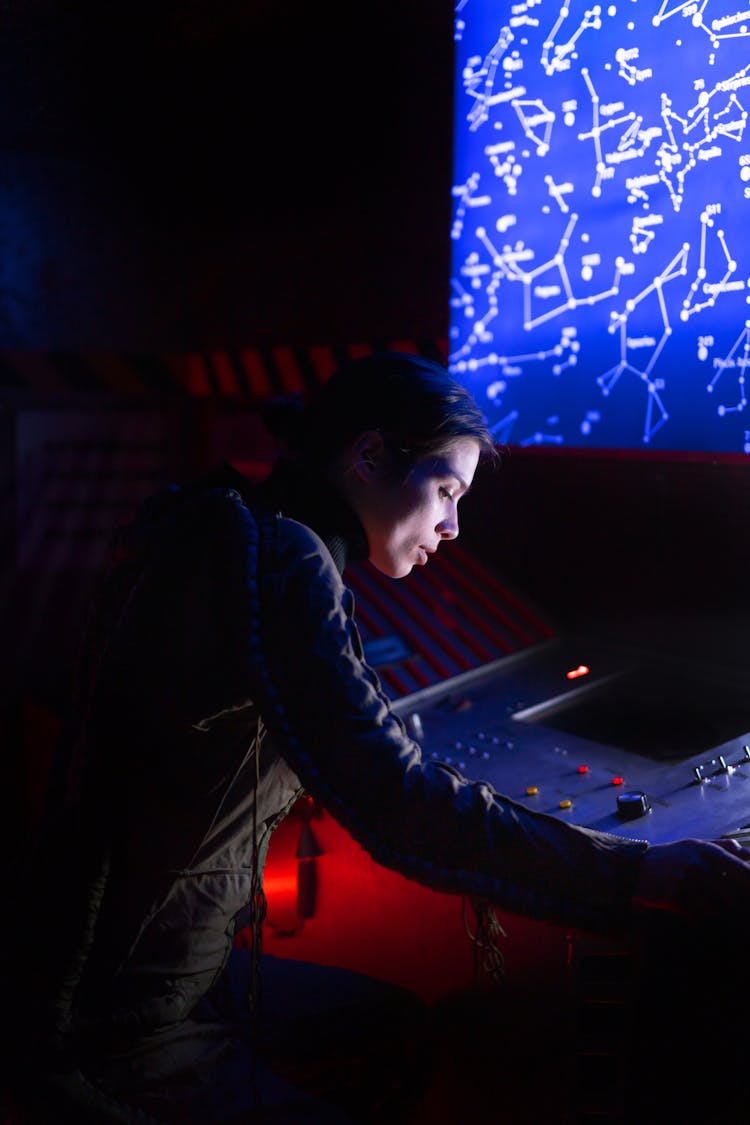 Woman In Spacesuit Looking At The Control Panel Of A Spacecraft