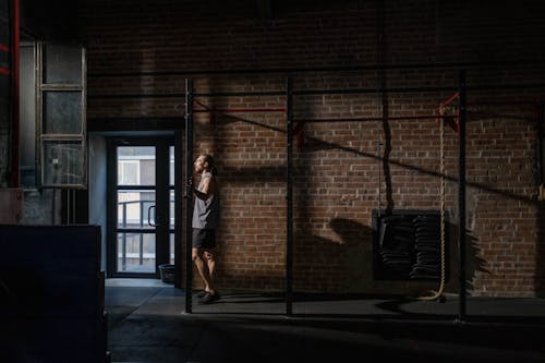 Free Man in Activewear Standing Near a Brick Wall Stock Photo