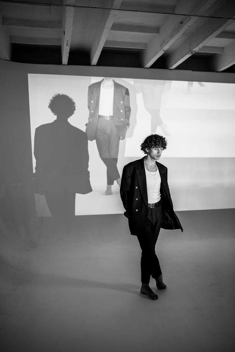 Man In Black Suit Standing Near A Projector Screen