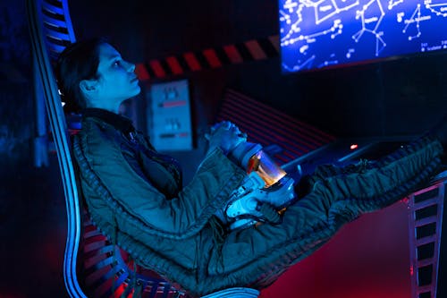 Woman Sitting On A Metal Chair Inside A Spacecraft