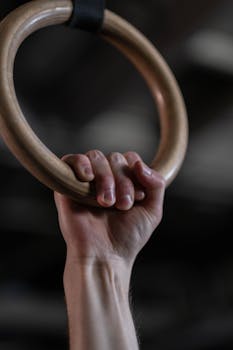 A hand firmly gripping a gymnastic ring, showcasing strength and focus