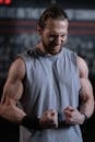 Man in Gray Tank Top Flexing His Muscles