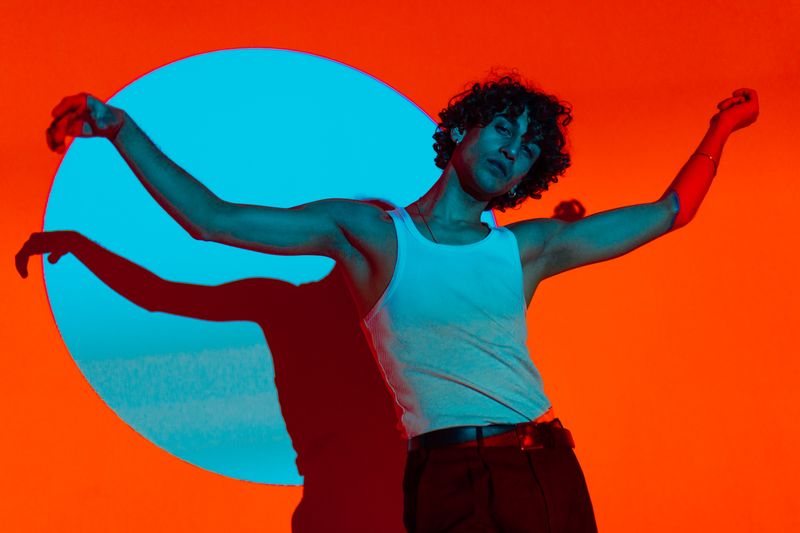 Dancer under vivid orange and blue stage light